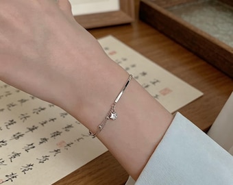This S925 sterling silver double-layered star pendant bracelet features a delicate double-chain bangle and an elegant adjustable wristband.