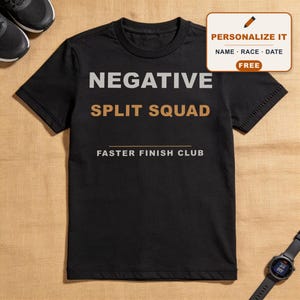 Puede incluir: Una camiseta negra de manga corta con el texto NEGATIVE en gris claro, SPLIT SQUAD en beige y FASTER FINISH CLUB en blanco. Un gráfico rectangular en la esquina muestra un icono de lápiz con el texto PERSONALIZE IT NAME RACE DATE FREE.