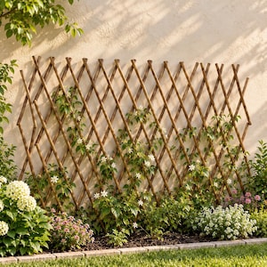 Puede incluir: Un enrejado de jardín extensible de madera marrón con un patrón de celosía en forma de diamante. La estructura está colocada verticalmente contra una pared de color claro, sirviendo de soporte para enredaderas verdes con flores blancas.