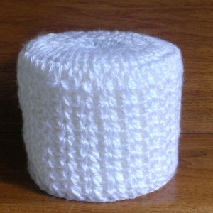 May include: White crocheted toilet paper roll cover. The cover is made with a simple stitch pattern and has a smooth, soft texture.