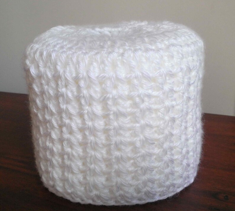 May include: White crocheted toilet paper roll cover.