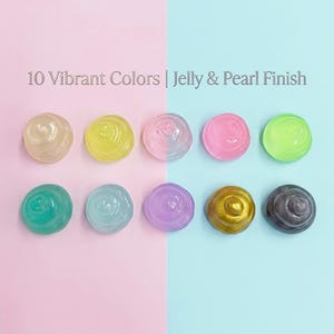 May include: Ten circular dollops of viscous material arranged in two rows of five. The colors include beige, yellow, light pink, hot pink, lime green, teal, light blue, purple, gold, and dark gray. Text reads: 10 Vibrant Colors | Jelly & Pearl Finish.