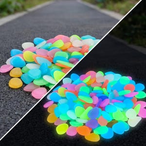 May include: A collection of small, smooth, multi-colored decorative stones in shades of blue, green, pink, orange, and yellow. The image shows two distinct groupings of these pebbles, with one set appearing to emit a vibrant glow in the dark.