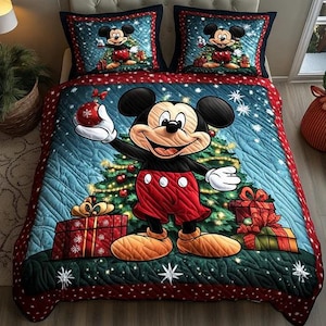 May include: A Christmas-themed bedding set featuring Mickey Mouse. The quilt and pillowcases display Mickey in front of a Christmas tree, surrounded by gifts and snowflakes. The color palette includes red, blue, green, and white.