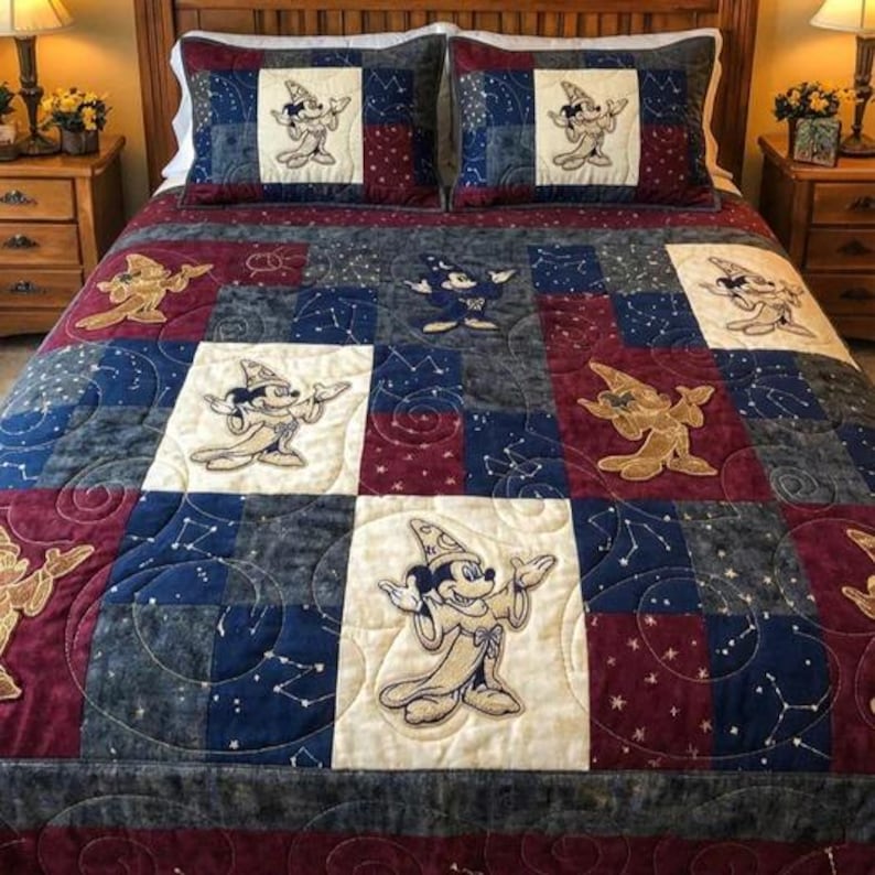 Puede incluir: Un edred&oacute;n de retazos y dos fundas de almohada con un patr&oacute;n repetido de Mickey Mouse con un disfraz de mago. El edred&oacute;n tiene una combinaci&oacute;n de colores azul marino, burdeos, crema y dorado. Las fundas de almohada tienen un fondo azul marino.