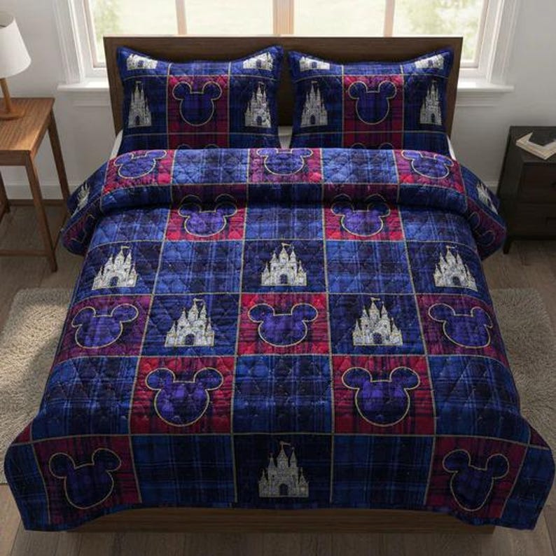Op de afbeelding: Een blauwe, rode en paarse geruite quiltset met bijpassende kussenslopen. De quilt heeft een patroon van Mickey Mouse-silhouetten en kasteelontwerpen. Het beddengoed is op een houten bedframe in een goed verlichte kamer geplaatst.