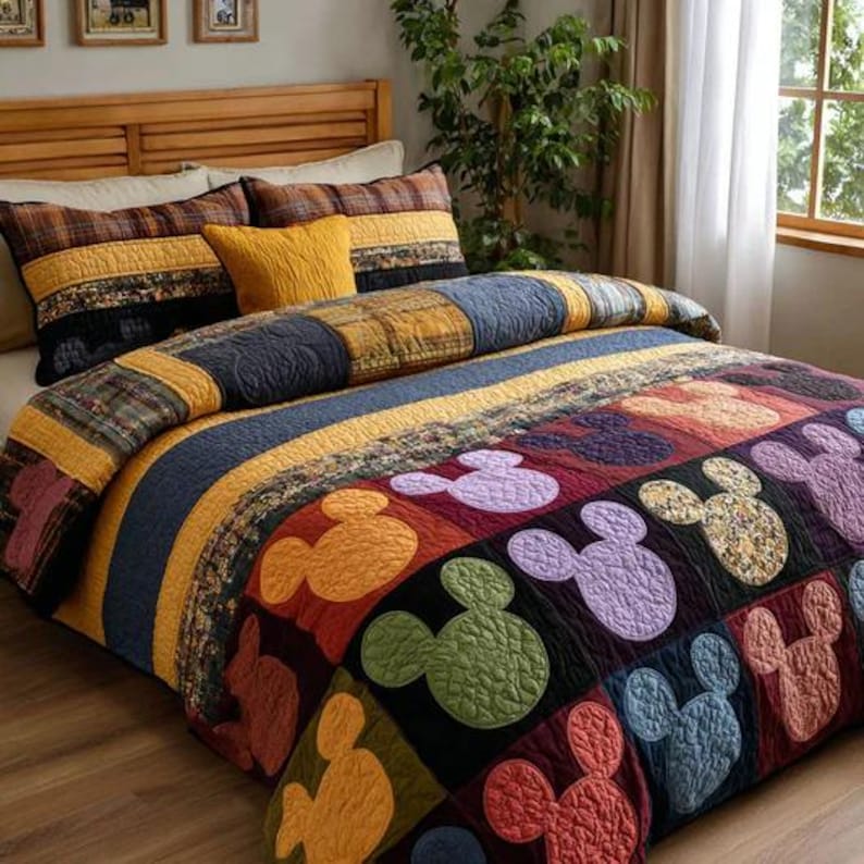 May include: A patchwork quilt with a Mickey Mouse design in various colors, including red, orange, green, purple, and blue. The quilt features a striped pattern with yellow, blue, and black sections. The bed is made up with matching pillows.