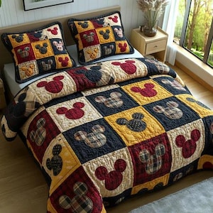 May include: A patchwork quilt and two pillow shams featuring a Mickey Mouse design. The bedding set has a color scheme of red, yellow, navy, and cream. The quilt and pillow shams are square-patterned with Mickey Mouse head shapes.