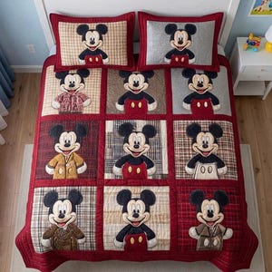 Może przedstawiać: Czerwono-beżowy zestaw kołdry Mickey Mouse z dwiema pasującymi poszewkami na poduszki. Kołdra posiada dziewięć kwadrat&oacute;w z r&oacute;żnymi wzorami Myszki Miki, każdy w innym stroju. Zestaw wykonany jest z pikowanej tkaniny.