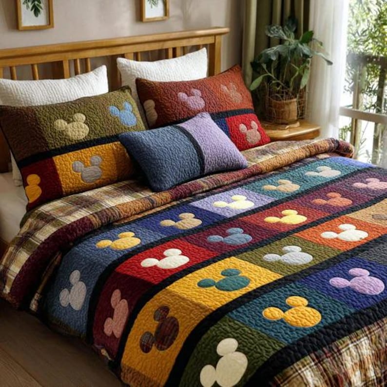 May include: A colorful patchwork quilt and pillow set featuring a Mickey Mouse design. The quilt showcases squares of various colors, each with a Mickey Mouse silhouette. The pillows and quilt have a plaid pattern.