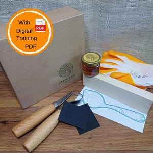 May include: A wood carving kit featuring a brown cardboard box with a Liowood logo, two metal carving tools with light wood handles, a small glass jar of oil, two black sandpaper squares, a white wooden block, and orange safety gloves.