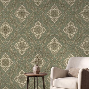 Peut inclure: Papier peint présentant un motif damassé répétitif dans des tons vert sauge et crème. Le design se compose de médaillons floraux complexes centrés dans des cadres en forme de losange, reliés par des motifs de feuilles d'acanthe et des lignes.