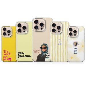 Può includere: Cinque cover per smartphone con vari design: una gialla con testo rosa It's messy but it's okay, una giallo pallido con testo nero yes, you can, una beige con una persona e un gatto con occhiali da sole, una a righe gialle con testo blu life is good, e una bianca floreale con una tazzina di caffè e testo one day at a time.