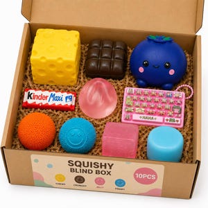 May include: A cardboard box labeled SQUISHY BLIND BOX 10PCS containing ten items: a yellow cheese block, a brown chocolate bar, a blue blueberry character, a Kinder Maxi bar, a pink translucent egg, a pink keyboard, an orange ball, a blue smiley ball, a pink cube, and a blue cylinder.