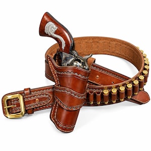Könnte beinhalten: Ein braunes Lederholster und ein passender Patronengürtel mit Messingschnalle und mehreren Messinghülsen. Ein Revolver mit poliertem Holzgriff und silberfarbener Metalleinlage sitzt sicher und fest in dem Holster.