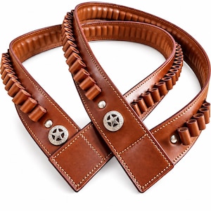 Può includere: Una cintura portacartucce in pelle marrone dotata di una serie di passanti per riporre le munizioni. La cintura è impreziosita da due conchos in metallo color argento, ciascuno inciso con una stella a cinque punte, e fissata con rivetti argentati.