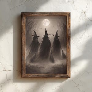 Pode incluir: Uma impressão de arte emoldurada em madeira castanha com uma ilustração em tons de sépia de três figuras com chapéus pontiagudos e capas compridas, cada uma segurando uma vassoura. A cena mostra uma floresta enevoada sob uma lua cheia.