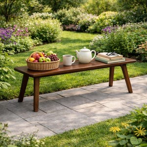 Può includere: Una panca in legno scuro in un giardino, con un cestino di vimini con frutta, una teiera bianca, una tazza e libri. La panca è circondata da vegetazione, fiori e un sentiero di pietra. La scena suggerisce un ambiente esterno tranquillo.