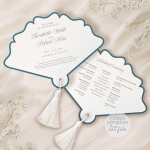Peut inclure: Deux programmes de mariage en forme d'éventail avec une bordure bleu foncé sur papier blanc. Les cartes présentent du texte imprimé en noir incluant les noms, dates et détails de la cérémonie. Chaque carte a un pompon blanc attaché.