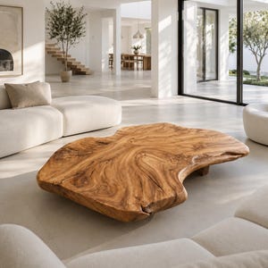 Könnte beinhalten: Ein großer, organisch geformter Couchtisch aus Holz mit einem natürlichen Holzmaserungsmuster. Der Tisch hat eine warme braune Farbe und steht niedrig auf dem Boden. Er ist der Mittelpunkt eines modernen Wohnzimmers.