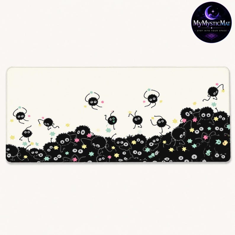 May include: A rectangular desk mat with a cream-colored background featuring a pattern of numerous small, round, black fuzzy creatures with large white eyes. The creatures are scattered across the bottom and floating above with colorful stars.