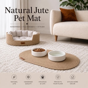 May include: An oval-shaped natural jute pet mat featuring a woven texture. Two white ceramic bowls with vertical ribbed sides sit on the mat, one containing brown dry food and the other filled with water. A small brown leather-like brand tag is attached.
