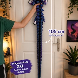 Könnte beinhalten: Ein bewegliches Drachenspielzeug mit einem Farbverlauf aus blauen, violetten und schwarzen Schuppen. Der Drache hat einen langen, segmentierten Schwanz und weiße Krallen. Der Text auf dem Bild gibt eine Länge von 105 cm an, Dragon articulé XXL.