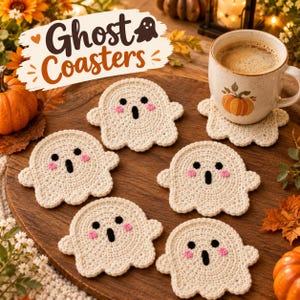 Puede incluir: Cinco posavasos de ganchillo en color blanco roto con forma de fantasma, ojos y bocas bordados en negro y mejillas rosas. Un posavasos sostiene una taza de cerámica con una ilustración de calabaza. El texto Ghost Coasters es visible.