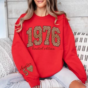 May include: A bright red crewneck sweatshirt featuring the year 1976 in a large leopard print font across the chest, with the text "limited edition" below it. The left sleeve displays the text "chapter 50" accompanied by a leopard print heart.
