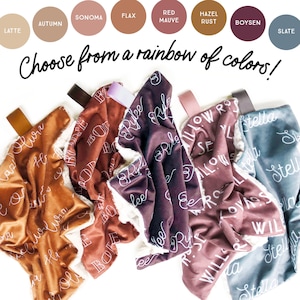 May include: Soft, plush baby blankets in various colors, including Latte, Autumn, Sonoma, Flax, Red Mauve, Hazel Rust, Boysen, and Slate. Each blanket features a white script name and a cozy sherpa lining. The text "Choose from a rainbow of colors!" is also visible.