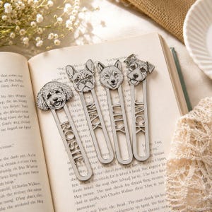 Può includere: Quattro segnalibri in metallo color argento, ognuno con la testa di una diversa razza di cane in cima e una targhetta con nome ritagliata verticalmente. I nomi Rosie, Max, Lily e Jack sono incisi sui gambi metallici di questi segnalibri.