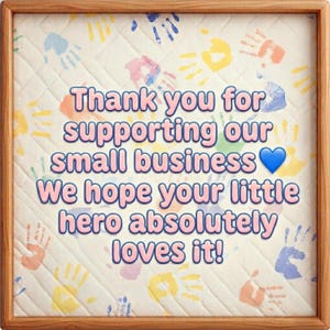 May include: A framed print with a quilted background and colorful handprints. The text says "Thank you for supporting our small business" and "We hope your little hero absolutely loves it!"