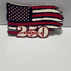 May include: A decorative emblem featuring a stylized, distressed American flag with horizontal red and white stripes and a blue field with white stars. The number 250 is prominently displayed in large red font with the word AMERICA written inside.