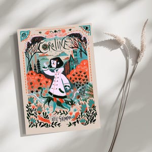 May include: A rectangular art print featuring a Coraline book cover illustration by Neil Gaiman. The design displays a character in a white coat with a black cat in a forest setting with orange and teal foliage, a house, and decorative borders.