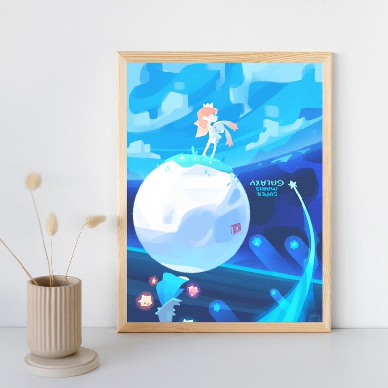 May include: A rectangular art print in a light wood frame featuring a stylized illustration of a character standing on a small planet against a blue space background. The text Super Mario Galaxy is printed in white on the right side of the image.