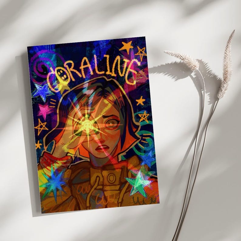 May include: A rectangular art print featuring a stylized illustration of a character with short hair wearing a yellow jacket. The text CORALINE is written in yellow at the top. The background is dark blue with colorful stars and swirling patterns.