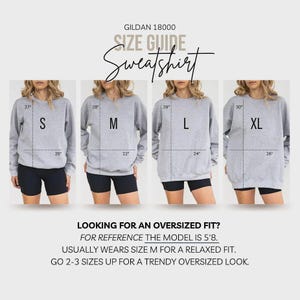 May include: A Gildan 18000 sweatshirt size guide featuring four grey sweatshirts labeled S, M, L, and XL. Each displays length and width measurements in inches. Text includes: Looking for an oversized fit? For reference the model is 5'8. Usually wears size M for a relaxed fit. Go 2-3 sizes up for a trendy oversized look.