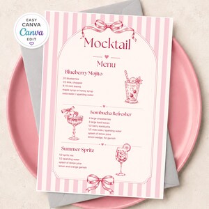 Op de afbeelding: Een rechthoekige menukaart met een roze en wit verticaal gestreepte rand, met de tekst Mocktail Menu. Het bevat recepten voor een Blueberry Mojito, Kombucha Refresher en Summer Spritz, vergezeld van roze lijntekeningen van cocktails en strikken.