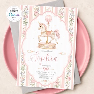 May include: A rectangular invitation card featuring a white unicorn carousel horse on a pink base, surrounded by a pink and white striped border with floral accents. The text reads: Come celebrate! Sophia is turning one, Sunday, April 21, 4:00 PM, Rose Garden Venue, 123 Blossom Lane, Springfield, CA.