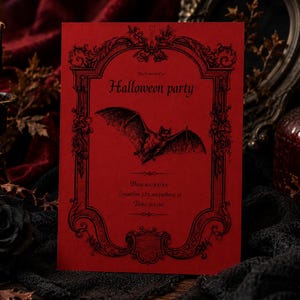 May include: A rectangular red invitation card featuring a black ornate frame, a central bat illustration, and the text "You're invited to Halloween party" followed by placeholders for date, location, and time printed in a black serif font.