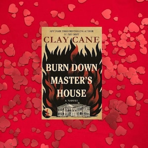 Puede incluir: Portada del libro "Burn Down Master's House" de Clay Cane, con un dise&ntilde;o ardiente y una ilustraci&oacute;n de una casa. La portada est&aacute; sobre un fondo rojo salpicado de confeti en forma de coraz&oacute;n. El autor es un autor de &eacute;xito del New York Times.