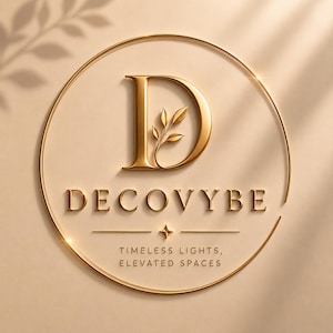 May include: A circular gold logo on a beige background featuring a large letter D with a small leaf sprig inside. Below the letter is the text DECOVYBE, a horizontal line with a four-pointed star, and the text TIMELESS LIGHTS, ELEVATED SPACES.
