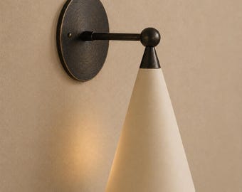May include: A wall sconce featuring a circular dark bronze mounting plate, a horizontal arm, and a downward-facing conical shade in a matte off-white finish. The fixture has a dark bronze finish on the metal components and a simple, clean design.