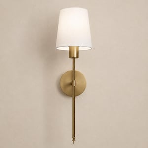 K&ouml;nnte beinhalten: Eine Wandleuchte mit einem Metallarm in geb&uuml;rsteter Messingoptik und einer runden Wandplatte. Die Leuchte verf&uuml;gt &uuml;ber einen einzelnen wei&szlig;en, konischen Stofflampenschirm, der das Licht nach unten richtet. Der vertikale Stab ragt nach unten.