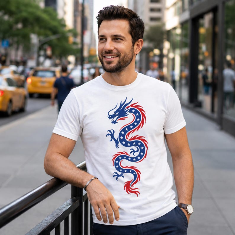 May include: A white short-sleeved t-shirt featuring a central graphic of a serpentine dragon. The dragon is coloured in blue with white stars and outlined in red, creating a stylised design that runs vertically down the centre of the chest area.