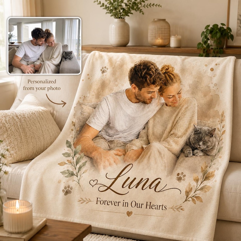 K&ouml;nnte beinhalten: Eine cremefarbene Fleecedecke mit einem aufgedruckten Foto einer Person und einer Katze. Das Design enth&auml;lt botanische Illustrationen, Pfotenabdr&uuml;cke und den Text "Luna" gefolgt von dem Schriftzug "Forever in Our Hearts" in Schreibschrift.