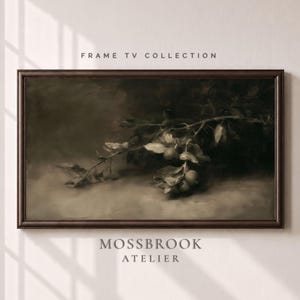 May include: A rectangular dark brown frame containing a horizontal landscape painting of a branch with small round fruits and leaves in muted sepia tones. The text FRAME TV COLLECTION and MOSSBROOK ATELIER is printed above and below the artwork.