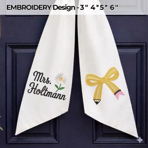 Pode incluir: Dois painéis de tecido branco com bordado à máquina. O painel esquerdo exibe o texto "Mrs. Holtmann" em letra cursiva preta acima de uma margarida branca. O painel direito apresenta um lápis amarelo em forma de laço com borracha rosa.
