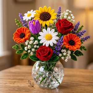 May include: A vibrant bouquet of handmade felt flowers in a clear glass vase. The arrangement includes sunflowers, daisies, poppies, roses, and lavender. The vase sits on a wooden table, creating a colorful floral display.