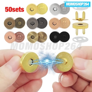 Op de afbeelding: Een verzameling van 50 sets ronde magnetische drukknopen in diverse metallic afwerkingen, waaronder goud, zilver, brons, gunmetal, roségoud en zwart. Elke set bestaat uit twee ronde onderdelen met pootjes voor bevestiging aan stof.